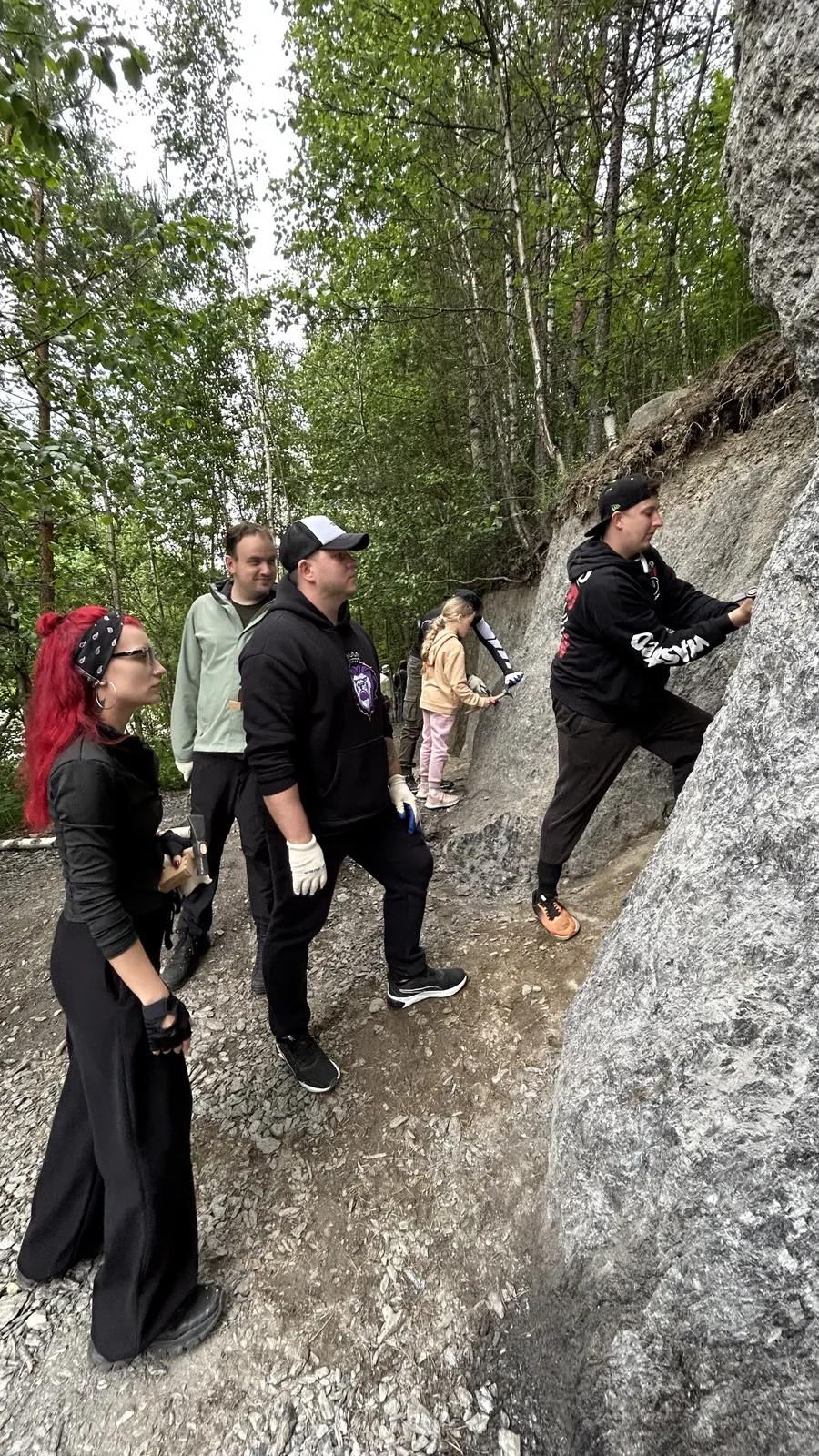 В рабочих перчатках у гранитной скалы, один поднимается по камню